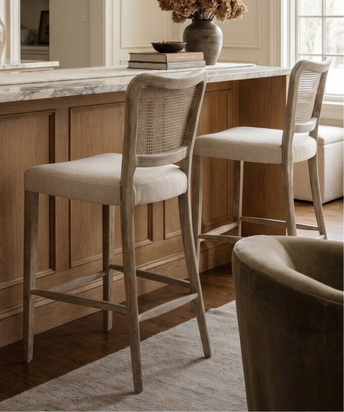 Woven counter stool beside a dark kitchen island